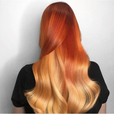 Vibrant red and orange hair blended with golden blonde waves cascading down the back, showcasing beautiful styling.