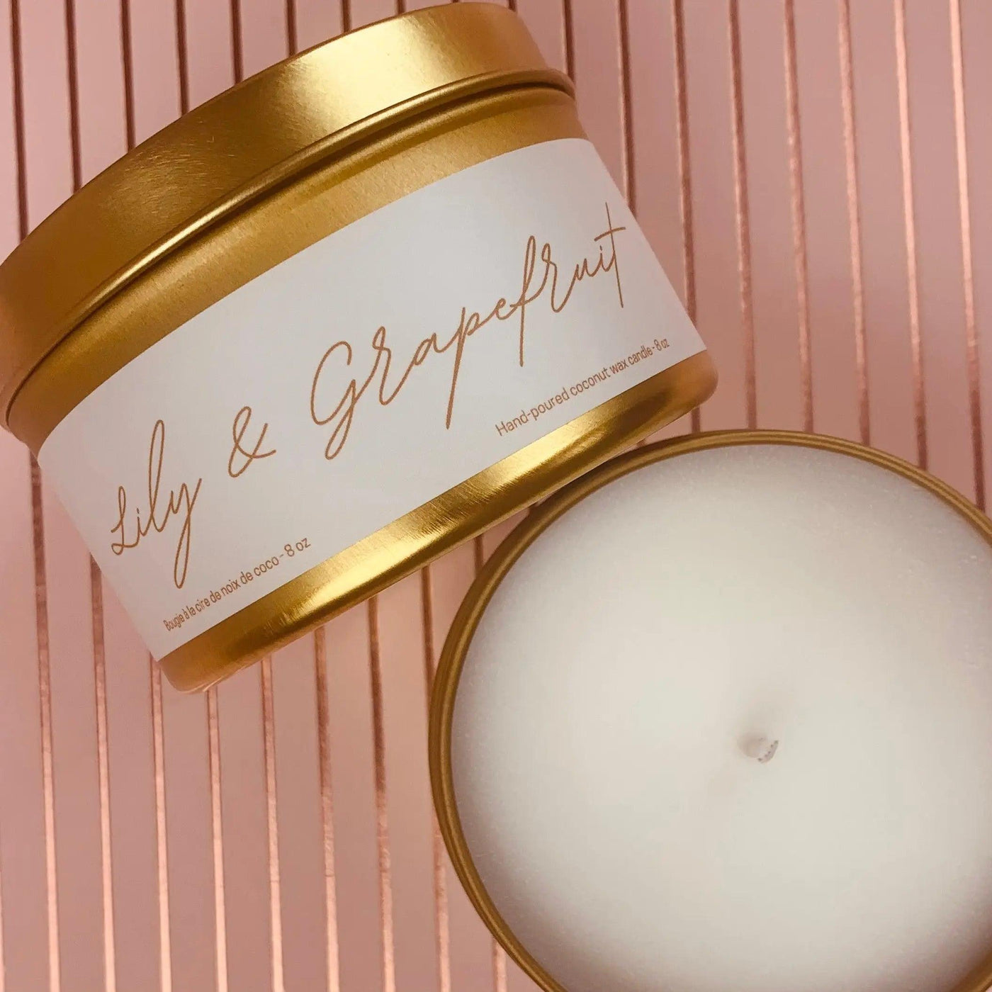 Gold metal tin candle labeled Lily & Grapefruit, showcasing scented coconut wax blend and essential oils.