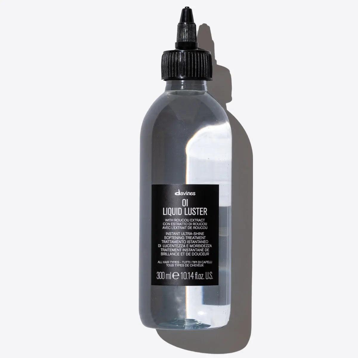 Oi Liquid Luster by Davines in a clear bottle, a weightless treatment for shiny, silky hair with a glass-like finish.