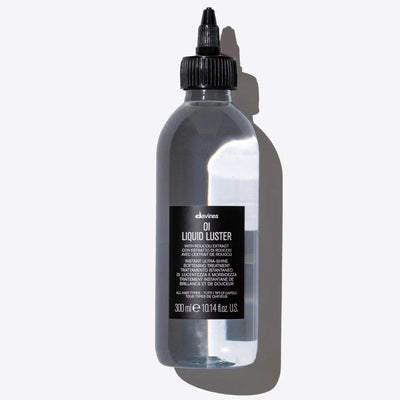 Oi Liquid Luster by Davines in a clear bottle, a weightless treatment for shiny, silky hair with a glass-like finish.