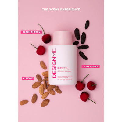 DESIGNME Puff Me Volumizing Conditioner surrounded by black cherry, almond, and tonka bean on pink background.