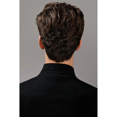 Back view of a man with wavy brown hair wearing a black shirt against a gray background.