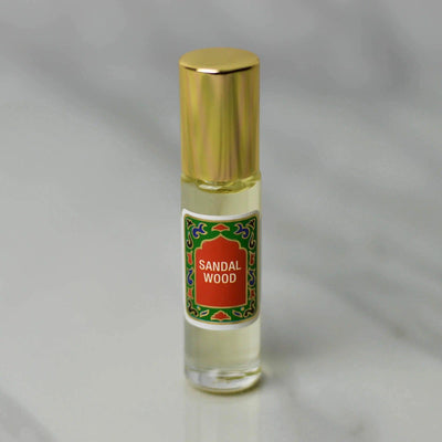 Sandalwood roll-on perfume in a 10ml bottle with gold cap, showcasing a warm and woody fragrance.