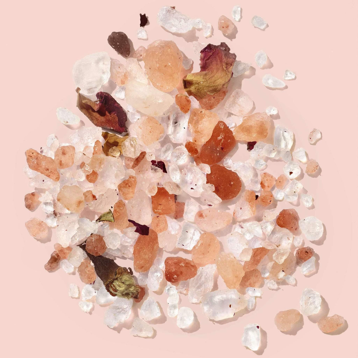 Himalayan pink salt with rose petals on a pink background