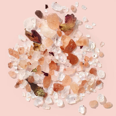 Himalayan pink salt with rose petals on a pink background