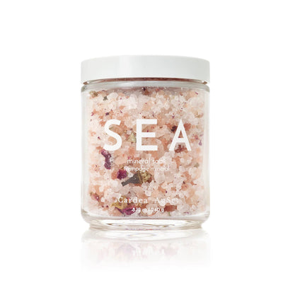 Sea mineral salt bath soak in a clear jar with white lid, perfect for relaxation and skin nourishment. Cardea Auset 240g spa product.