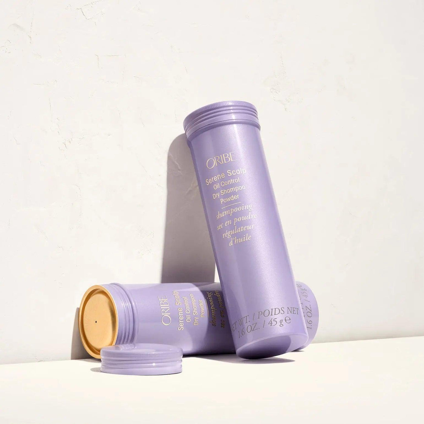 Serene Scalp Oil Control Dry Shampoo Powder by Oribe in purple packaging on a light background.