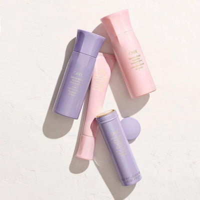 Oribe Serene Scalp Oil Control Treatment Mist and hair care products in pastel bottles on a light background.
