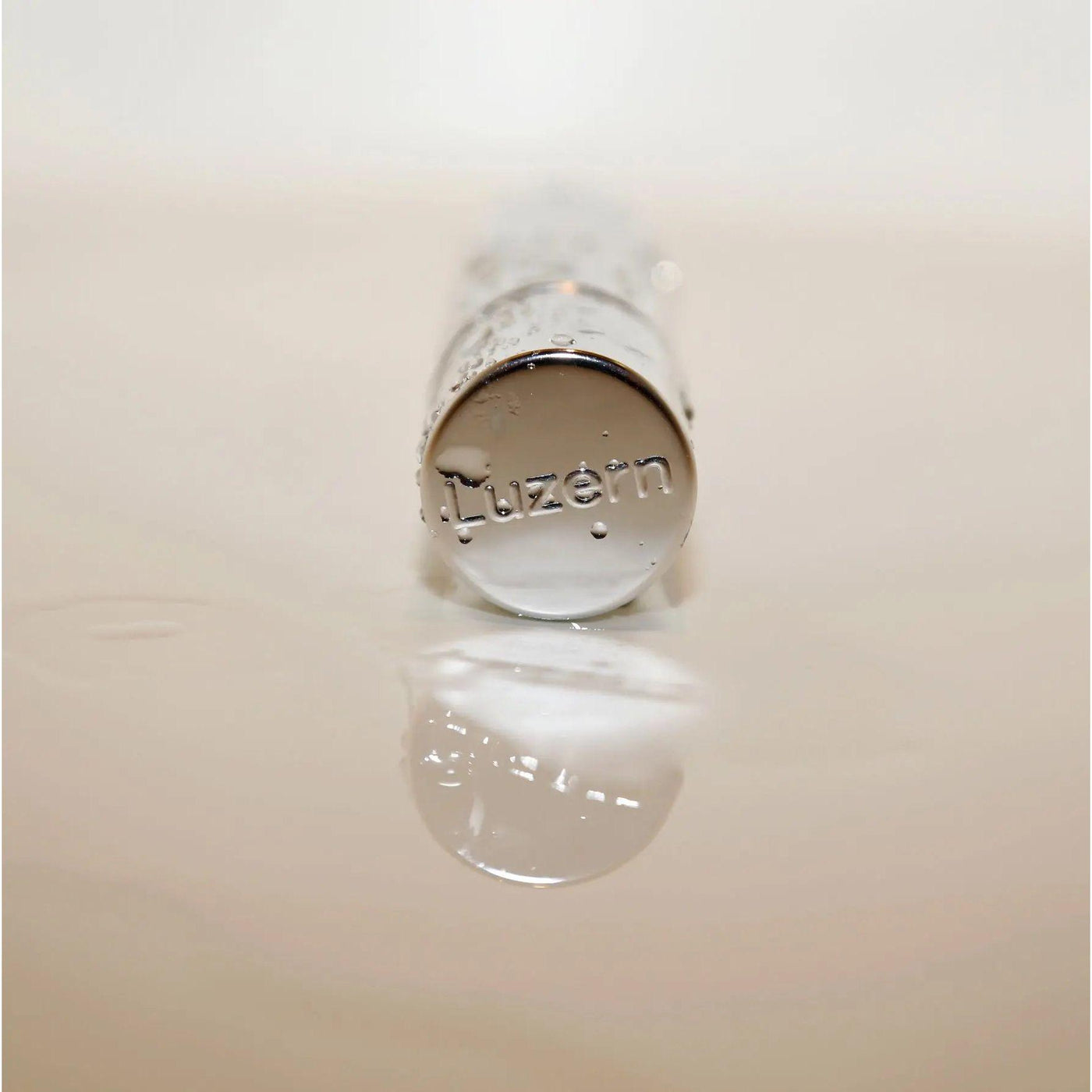 Close-up of Luzern serum bottle featuring a reflective surface, showcasing luxury skincare packaging.
