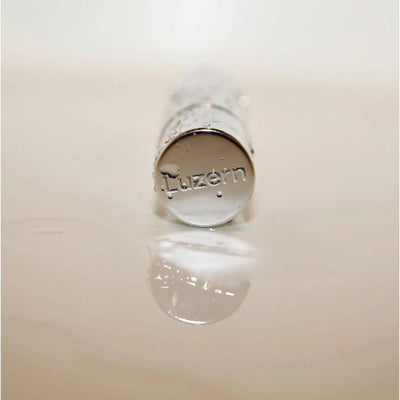 Close-up of Luzern serum bottle featuring a reflective surface, showcasing luxury skincare packaging.