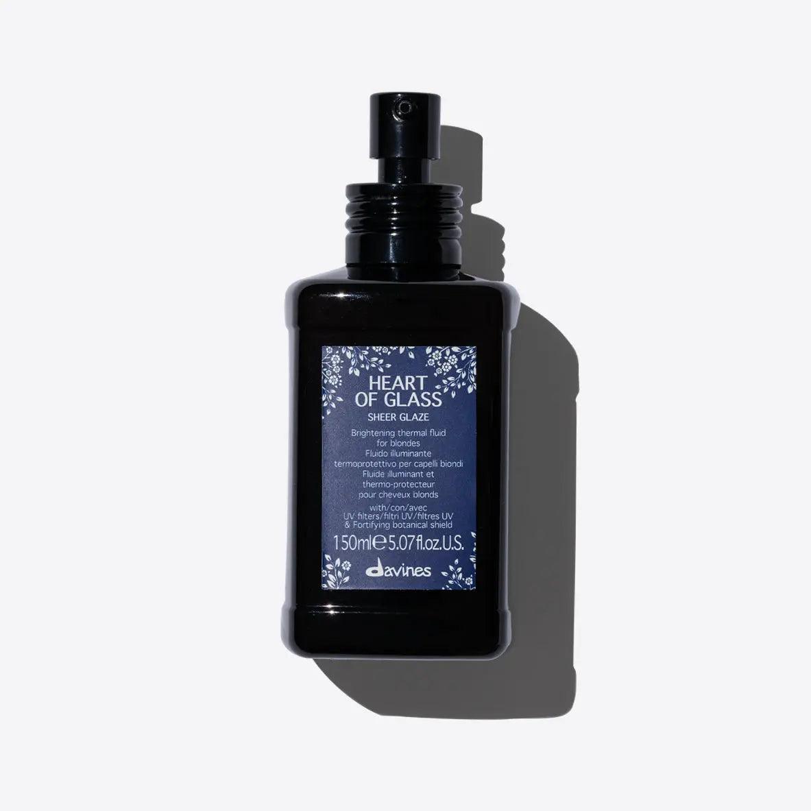 Sheer Glaze brightening thermal fluid for blondes, providing hydration, shine, and UV protection in a sleek spray bottle.