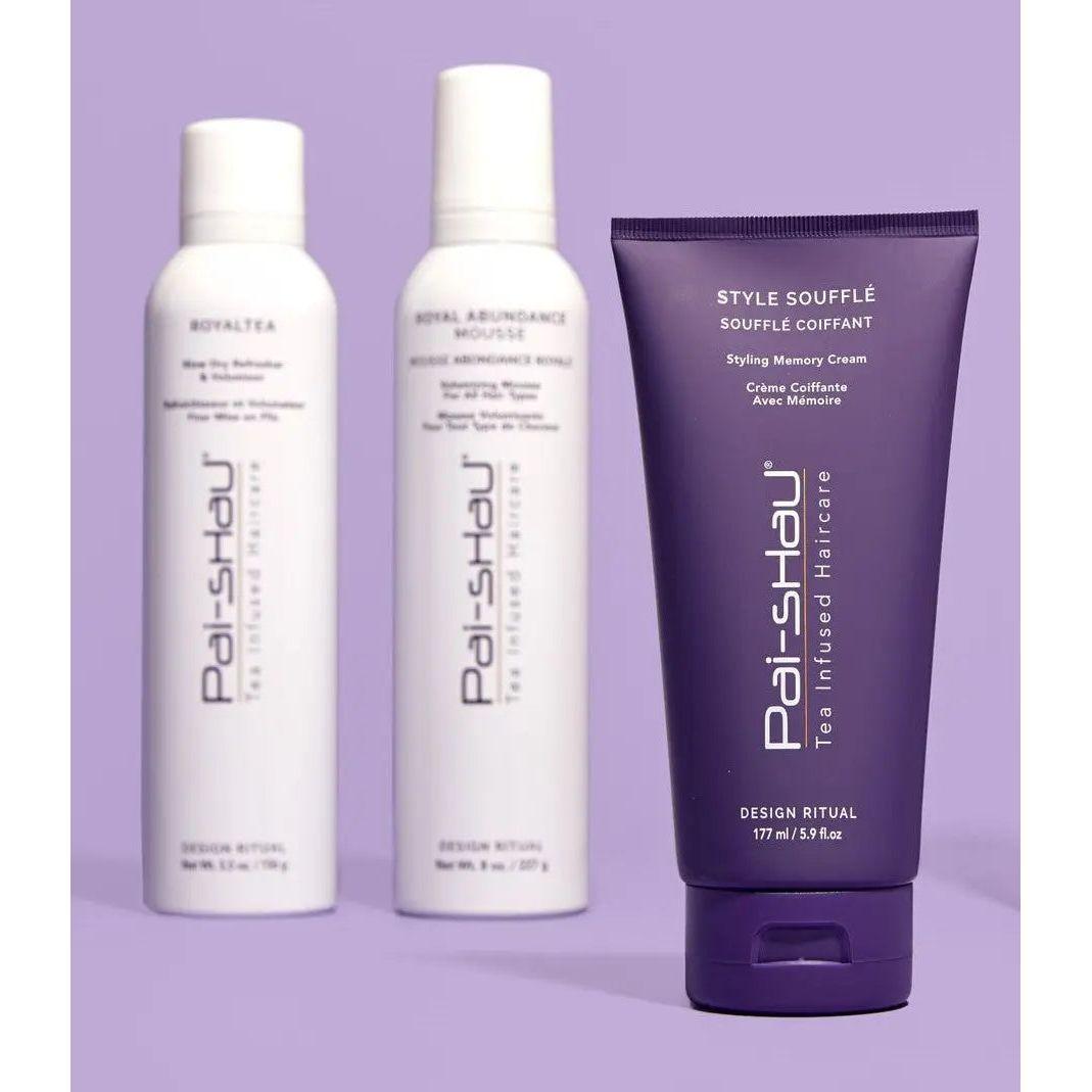 Three hair care products including Style Soufflé styling cream and Royal Abundance Mousse on a purple background.