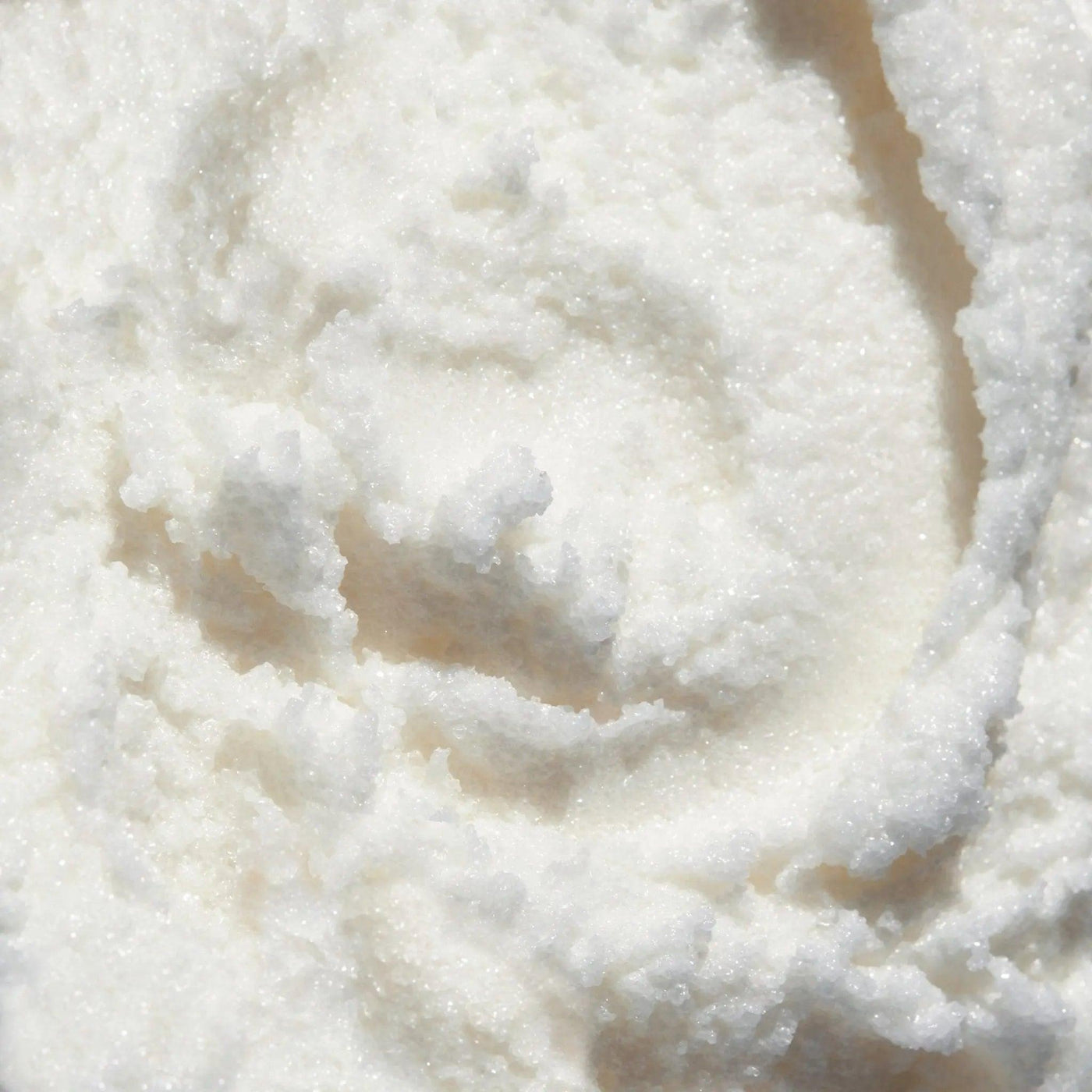 Close-up of sugar coconut scrub showcasing a smooth, creamy texture ideal for exfoliation and hydration.