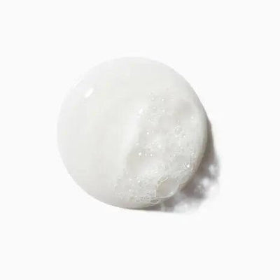 White, foamy texture of Symbiose Bain Crème Apaisant gentle cleansing shampoo from Kerastase.