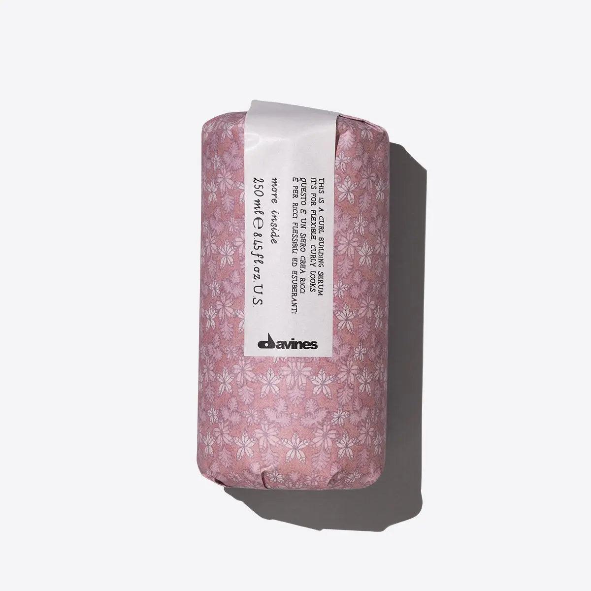 "Davines hair product wrapped in pink floral packaging on white background"